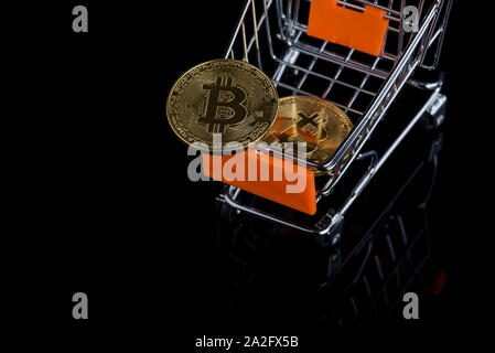 Bitcoin & cryptocurrency im Warenkorb auf schwarzem Hintergrund Stockfoto