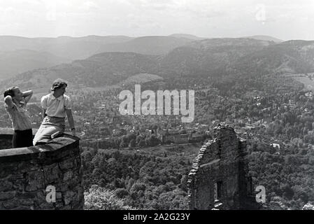 Zwei junge Frauen genießen den Ausblick von der Schlossruine Hohenbaden im Nordschwarzwald in die Stadt Baden-Baden, Deutschland 1930er Jahre. Zwei junge Frauen genießen Sie den Blick auf Baden-Baden von der Ruine Hohenbaden Schloss, Deutschland 1930. Stockfoto