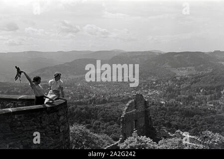 Zwei junge Frauen genießen den Ausblick von der Schlossruine Hohenbaden im Nordschwarzwald in die Stadt Baden-Baden, Deutschland 1930er Jahre. Zwei junge Frauen genießen Sie den Blick auf Baden-Baden von der Ruine Hohenbaden Schloss, Deutschland 1930. Stockfoto