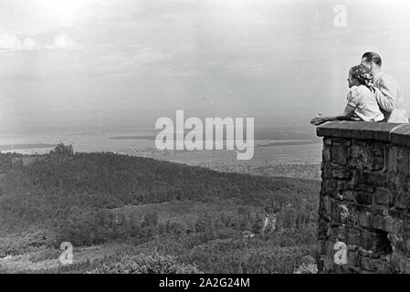 Ein junges Paar genießt den Ausblick von der Schlossruine Hohenbaden im Nordschwarzwald in die Stadt Baden-Baden, Deutschland 1930er Jahre. Ein junges Paar genießt den Blick auf Baden-Baden von der Ruine Hohenbaden Schloss, Deutschland 1930. Stockfoto