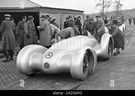 Vorsichtig wird der Mercedes Benz W 125 zum Start des Weltrekordversuchs geschoben, Deutschland 1930er Jahre. Vorsichtig den Mercedes Benz W125 ist auf den Beginn der Weltrekord Versuch schob, Deutschland 1930. Stockfoto