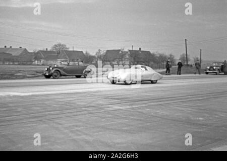 Ein kleines Rennauto vor dem Start auf der Strecke zum Weltrekordversuch mit dem Mercedes Benz W 125, Deutschland 1930er Jahre. Eine kleine Rennwagen vor dem Start auf der Rennstrecke für den Weltrekord Versuch mit der Mercedes Benz W 125, Deutschland 1930. Stockfoto