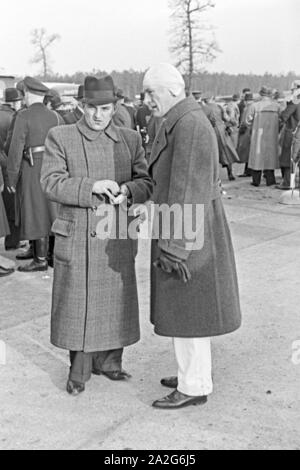 Der Rennfahrer Rudolf Caracciola im Gespräch vor dem Start zum Weltrekordversuch mit dem Mercedes Benz W 125, Deutschland 1930er Jahre. Rennfahrer Rudolf Caracciola im Gespräch mit einem Beamten vor dem Start in den Weltrekord Versuch mit der Mercedes Benz W 125, Deutschland 1930. Stockfoto