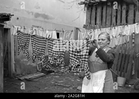 Die Großmutter macht die Wäsche und Knipser Vierlinge, Deutschland 1930er Jahre. Großmutter ist das Waschen von quadruplet Mädchen Knipser, Deutschland 1930. Stockfoto