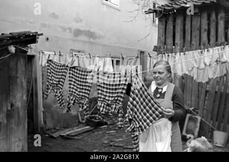 Die Großmutter macht die Wäsche und Knipser Vierlinge, Deutschland 1930er Jahre. Großmutter ist das Waschen von quadruplet Mädchen Knipser, Deutschland 1930. Stockfoto