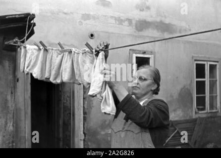 Die Großmutter macht die Wäsche und Knipser Vierlinge, Deutschland 1930er Jahre. Großmutter ist das Waschen von quadruplet Mädchen Knipser, Deutschland 1930. Stockfoto