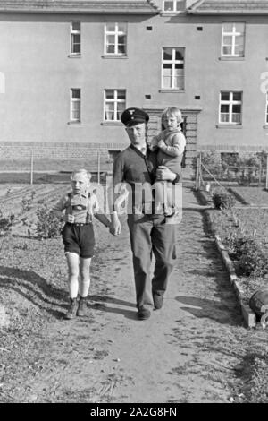 Ein Mann kommt mit zwei kleinen Kindern an der Hand aus einem Haus auf der Halbinsel Hela in Ostpreußen, Deutschland 1930er Jahre. Ein Mann mit zwei kleinen Kindern auf seinen Händen aus einem Haus an der Hela in Ostpreußen, Deutschland 1930. Stockfoto