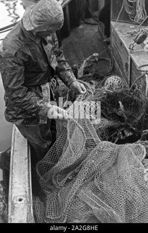 Ein Fischer vor-bereitet sterben Netze zum Fischfang in der Ostsee, Deutschland 1930er Jahre. Ein Fischer vorbereiten, die Netze für die Fischerei in der Ostsee, Deutschland 1930. Stockfoto