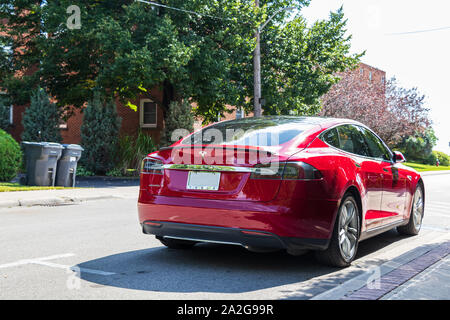 Red Tesla Model S parkte an einem hellen, sonnigen Tag an der Straßenseite. Stockfoto