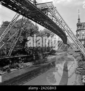 Die Strecke der Wuppertaler Schwebebahn spiegelt sich in der Wupper, Deutschland 1930er Jahre. Wuppertaler Schwebebahn refelcting in die Wupper, Deutschland 1930. Stockfoto