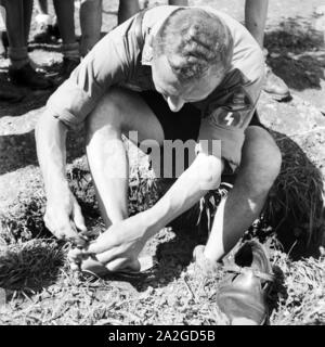 Ein Hitlerjunge im Hitlerjugend Lager bei der Fußpflege als Vorbereitung zum Marsch, Österreich 1930er Jahre. Ein Hitler Jugend Pflege für seine Füße als Vorbereitung für eine März an der Hitler Jugend Camp, Österreich 1930. Stockfoto