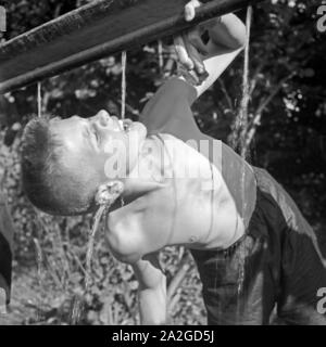 Ein Junge trinkt Wasser aus einer Leitung im Hitlerjugend Lagerbier, Österreich 1930er Jahre. Ein jungen Trinkwasser an der Hitler Jugend Camp, Österreich 1930. Stockfoto