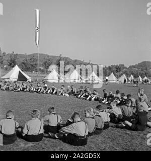 Sitzkreis zur Empfang des Tagesbefehls im Hitlerjugend Lagerbier, Österreich 1930er Jahre. Sitzen und Warten auf die Tagesordnung an Hitler Youth Camp, Österreich 1930. Stockfoto