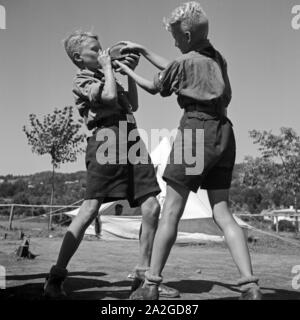 Zwei durstige Hitlerjungen streiten um die Wasserflasche im Hitlerjugend Lagerbier, Österreich 1930er Jahre. Zwei durstige Hitler Jugend für eine Flasche Wasser am Hitler Youth Camp streiten, Österreich 1930. Stockfoto