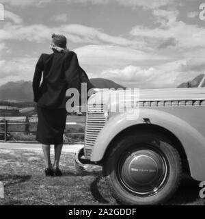 Eine Junge Frau Steht eine der Kühlerhaube Eines Opel Olympia, 1930er Jahre Österreich. Eine junge Frau von der Motorhaube von einem Opel Modell Olympia, Österreich der 1930er Jahre. Stockfoto