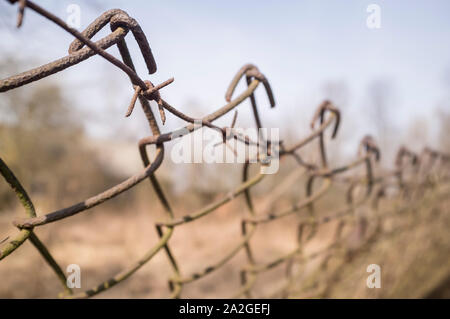 Alten verrosteten Zaun aus metall gitter und Stacheldraht. Close-up Stockfoto