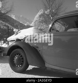 Ford Eifel vor einer Station der Zugspitzbahn, Deutschland 1930er Jahre. Ford Modell Eifel in fornt einer Station der Zugspitzbahn Bergbahn, Ge Stockfoto