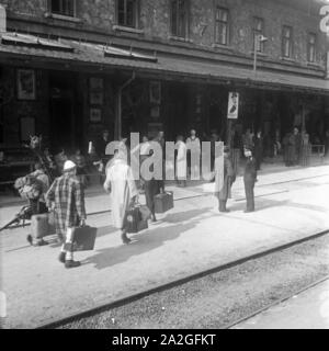 Skiurlauber vor dem Bahnhof in Landeck in Tirol, Deutschland 1930er Jahre. Ski Touristen am Bahnhof Landeck, Deutschland 1930. Stockfoto