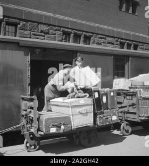 Gepäckträger mit dem zugangsweg am Bahnhof in Hamburg, Deutschland 1930er Jahre. Gepäckträger auf einer Plattform des Hamburger Hauptbahnhofs, Deutschland 1930. Stockfoto