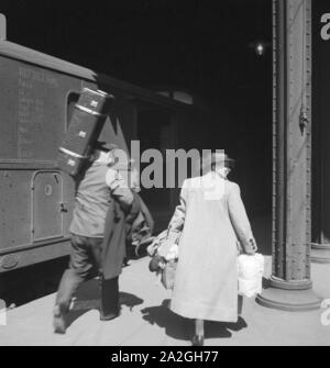 Gepäckträger mit dem zugangsweg am Bahnhof in Hamburg, Deutschland 1930er Jahre. Gepäckträger auf einer Plattform des Hamburger Hauptbahnhofs, Deutschland 1930. Stockfoto