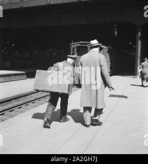 Gepäckträger mit dem zugangsweg am Bahnhof in Hamburg, Deutschland 1930er Jahre. Gepäckträger auf einer Plattform des Hamburger Hauptbahnhofs, Deutschland 1930. Stockfoto