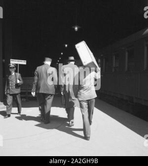 Gepäckträger mit dem zugangsweg am Bahnhof in Hamburg, Deutschland 1930er Jahre. Gepäckträger auf einer Plattform des Hamburger Hauptbahnhofs, Deutschland 1930. Stockfoto