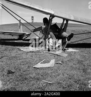 Hitlerjunge als Bruchpilot in den Trümmern Waden Segelflugzeugs auf der Reichssegelflugschule Wasserkuppe bei Fulda, Deutschland 1930er Jahre. Hitler Jugend in die Reste seines Segelfliegen Ebene auf die Reichssegelflugschule für gleitflug an der Wasserkuppe in der Nähe von Fulda, Deutschland 1930. Stockfoto