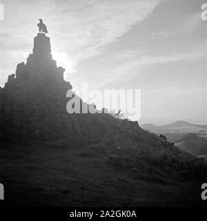 Im Gegenlicht: Das 1923 errichtete Fliegerdenkmal für sterben im 1. Weltkrieg gefallenen Feldpiloten auf dem Westhang der Wasserkuppe, Deutschland 1930er Jahre. In der Hintergrundbeleuchtung: WWI Denkmal, errichtet im Jahre 1923, für gefallene Piloten an den westlichen Hängen der Wasserkuppe, Deutschland 1930. Stockfoto