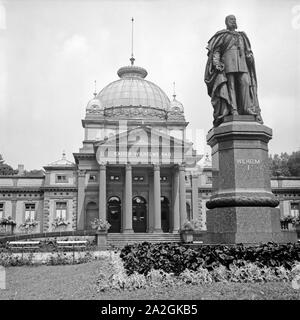 Blick in das Kaiser Wilhelms schlecht mit dem Denkmal für Kaiser Wilhelm I. in Bad Homburg, Deutschland 1930er Jahre. Blick auf die Kaiser-Wilhelms-Bad mit Kaiser Wilhelm I. Denkmal in Bad Homburg, Deutschland 1930. Stockfoto