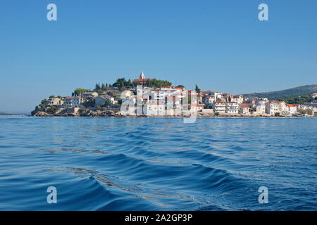 Segeln oder Motorboot auf der Adria mit Primosten Stadtbild im Hintergrund. Urlaub in Kroatien Stockfoto