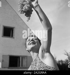 Eine junge Frau mit Weintrauben, Deutschland 1930er Jahre. Eine junge Frau mit Trauben, Deutschland 1930. Stockfoto