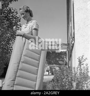 Eine junge Frau mit Luftmatratze, Deutschland 1930er Jahre. Eine junge Frau mit einer Luftmatratze, Deutschland 1930. Stockfoto