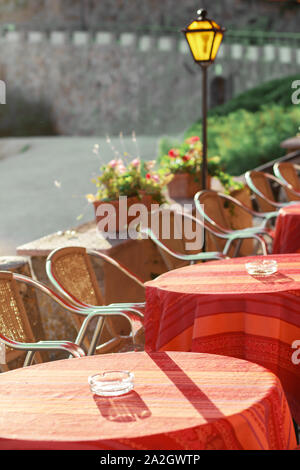 Eine Reihe von Tabellen mit roten Tischdecken auf der Terrasse eines Restaurants in der Stadt am Meer. Close-up, unscharfen Hintergrund, geringe Tiefenschärfe, su Stockfoto