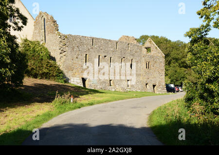 Das ehemalige Kloster in Penmon auf Anglesey, das auch die alte Dovecote auf der rechten Seite zeigt. Stockfoto