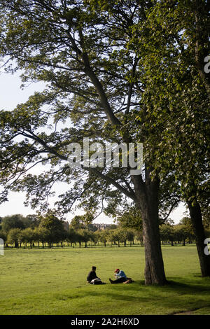 Freunde genießen Sie mittags in einem Park im Stadtzentrum von Edinburgh an den Wiesen Stockfoto