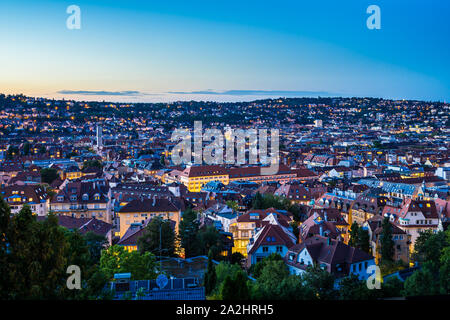 Deutschland, magische Sommer Sonnenuntergang Himmel über urbane Stadtbild von Stuttgart City Häuser und Dächer, Luftbild von oben über beleuchtete Skyline Stockfoto
