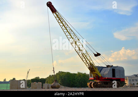 Große Raupenkran oder schleppschaufel Hydraulikbagger mit einem heavy metal Abrissbirne an einem Stahlseil. Wrecking Ball auf Baustellen. Demontage und Dm Stockfoto