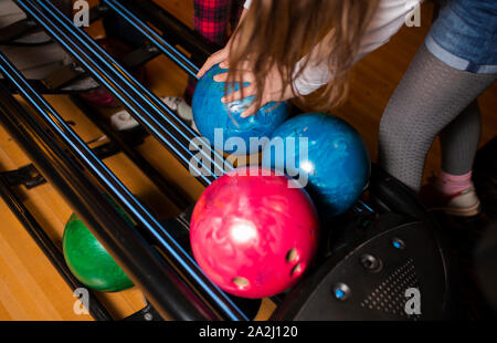 Close-up Hand Bowling Kugel gegen Bowlingbahn - Bild. Fröhliche Frau isready zu spielen - Bild. Die Kegelbahn Maschine return System con Stockfoto