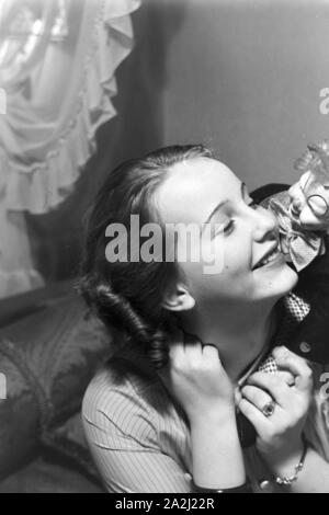 Mit Clown: die Prinzessin der Fastnacht in Mainz, Hildegard Kühne im Jahre 1938 zum hundertjährigen Jubiläum des Mainzer Carneval Verein (MCV) Wirtschaft in Nieder-Olm. Mit einem Clown: die Prinzessin des Karnevals in Mainz 1938, anlässlich des 100. Jahrestages der führenden lokalen Karnevalsverein, zu Hause in Nieder-Olm. Stockfoto