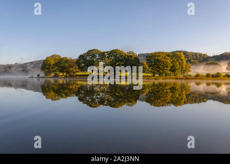 Herbstfarben im Esthwaite Wasser spiegelt wie die frühen Morgennebel genehmigt Stockfoto