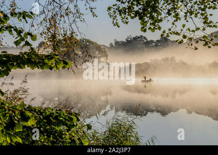 Am frühen Morgen Angelausflug auf Estwaite Wasser in den nebligen Herbst Sonnenschein Stockfoto