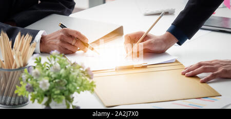 Nahaufnahme der Hand zwei Unternehmer diskutieren Reporting das Dokument auf dem Schreibtisch im Büro. Stockfoto