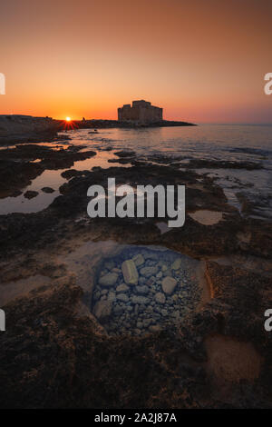 Schöne Aussicht auf den Sonnenuntergang über der alten Burg von Paphos, den Hafen und das Meer in Paphos, Zypern Stockfoto