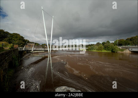 Die Lune Millenium Brücke überspannt den Fluss Lune im Lancaster in Lancashire. Der Fluss Lune ist hier nach schweren Regenfällen Ende September gesehen. Stockfoto