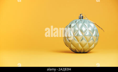 Schöne Weihnachten silber Kugel Tand in der Nähe auf einem gelben Hintergrund. Stockfoto