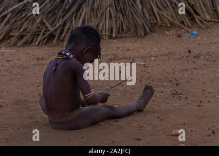 Turmi, Äthiopien - Nov 2018: Junge Hamer Stamm kid neben dem Haus spielen, Omo Valley Stockfoto