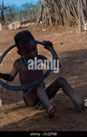 Turmi, Äthiopien - Nov 2018: Junge Hamer Stamm Kid spielen mit reifen, Omo Valley Stockfoto