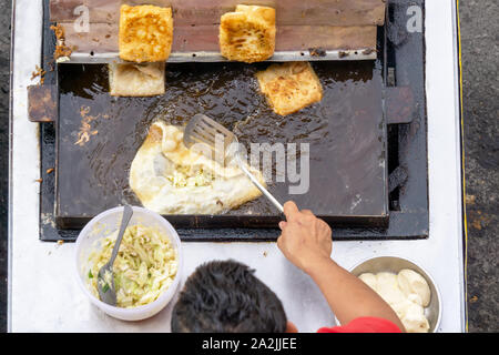 Draufsicht eines Mannes hand Kochen Gemüse Martabak Jawa in Kota Kinabalu City offenen Markt in Sabah Borneo. Martabak Jawa auch bekannt als gefüllte Pfannkuchen Stockfoto