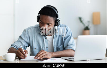 Schwere afrikanische amerikanische Studenten in Kopfhörer Studium ausländische Sprache online Stockfoto