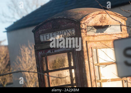 Eine alte verlassene rote Telefonzelle an der Seite der Straße in Cumbria. Stockfoto